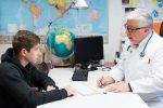 Rheuma: Arzt spricht mit jugendlichem Patienten